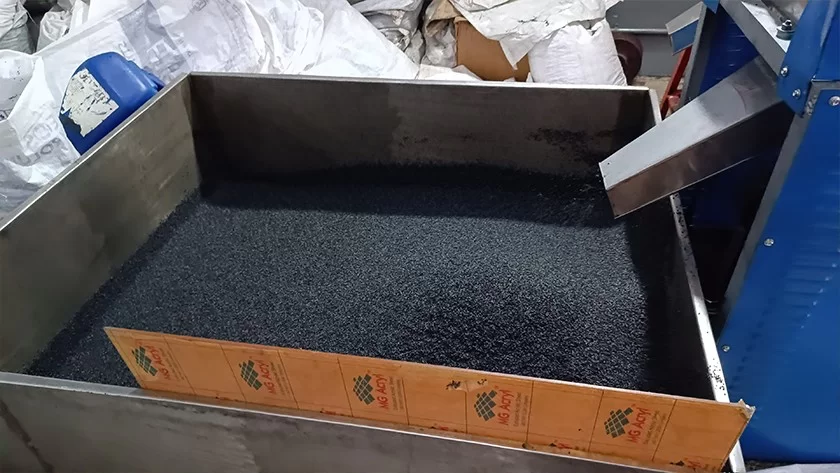 Tray of processed black granules at a Deshwal facility