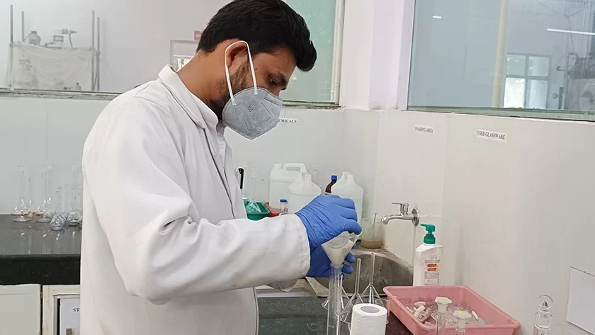 Deshwal laboratory analyst in a lab coat handling a sample
