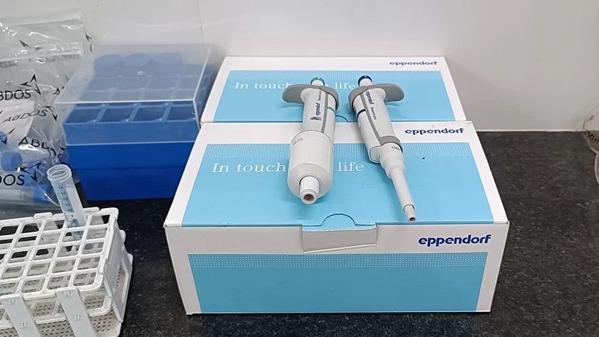 Laboratory pipettes and sample racks on a Deshwal lab bench